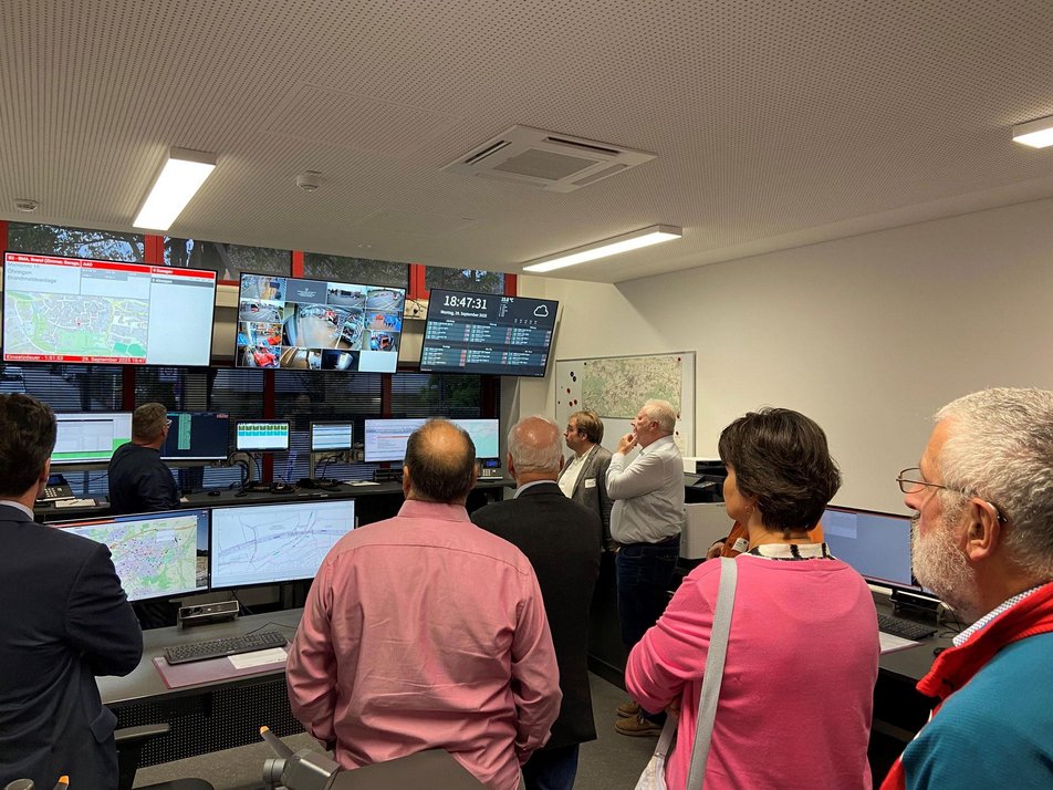 Teilnehmende in Einsatzzentrale Teilnehmende des Wirtschaftsstammtisches stehen in Einsatzzentrale